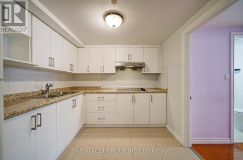 A kitchen with white cabinets and a granite countertop.