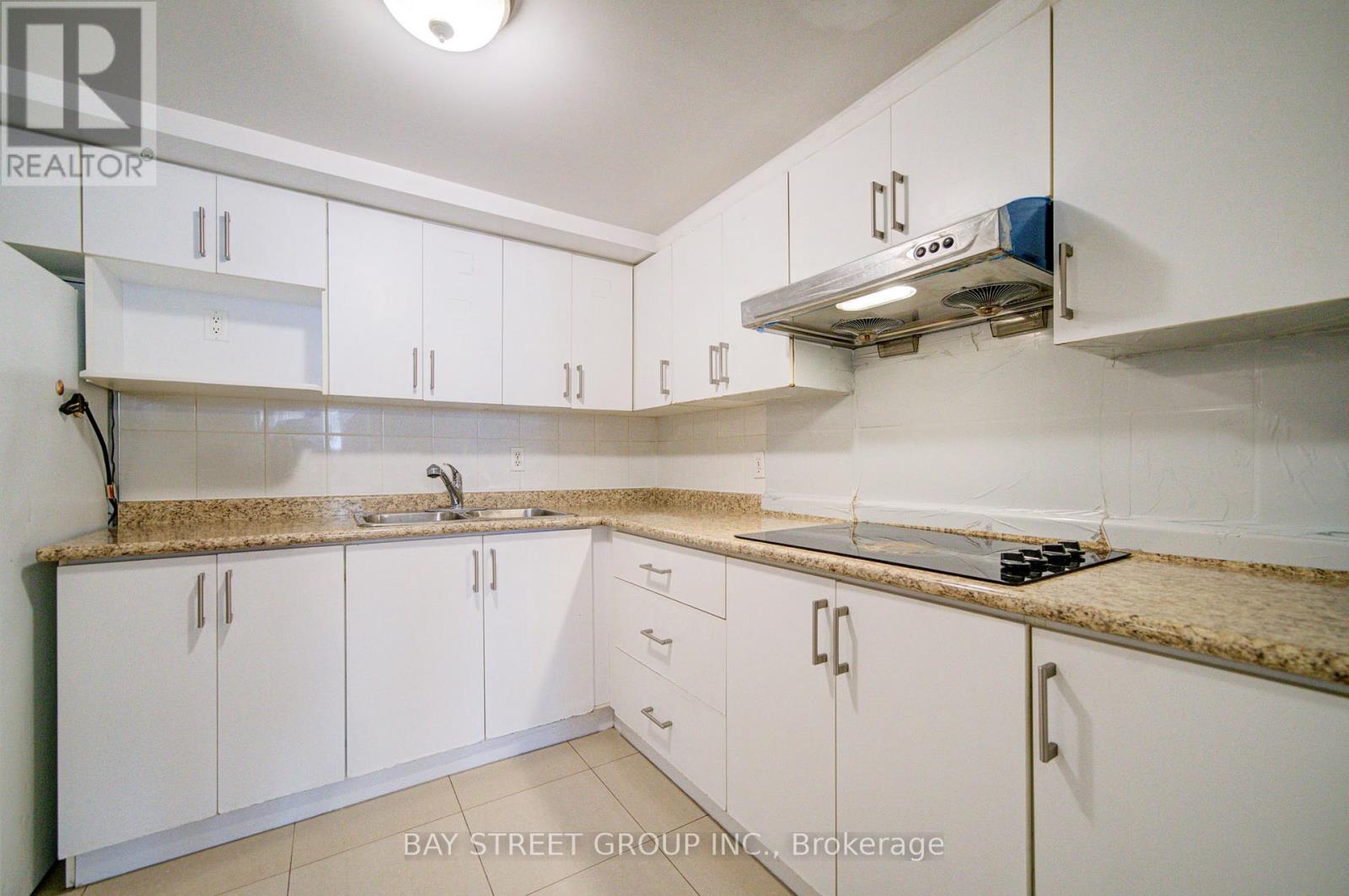A kitchen with white cabinets and a granite countertop.