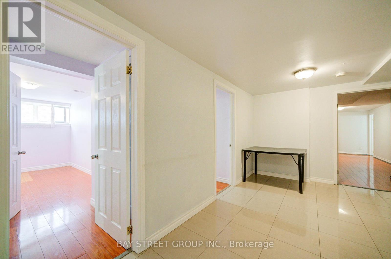 A white door opens to a room with a bench and tiled flooring.