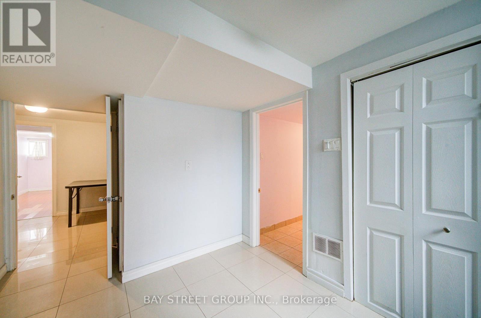 A white door is open to a room with a tiled floor.