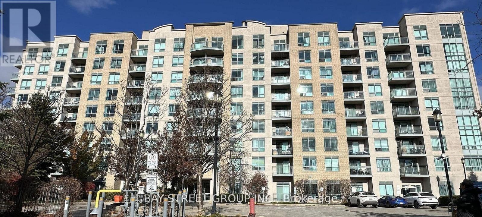 A large apartment building with a parking lot in front.