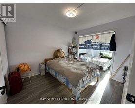 A bedroom with a bed, a chair, and a suitcase.