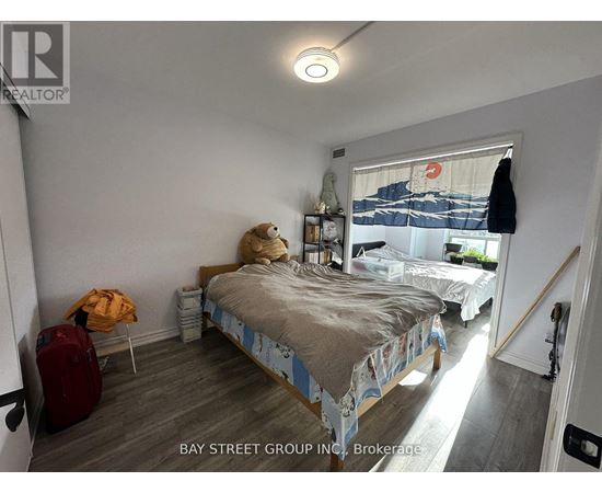 A bedroom with a bed, a chair, and a suitcase.