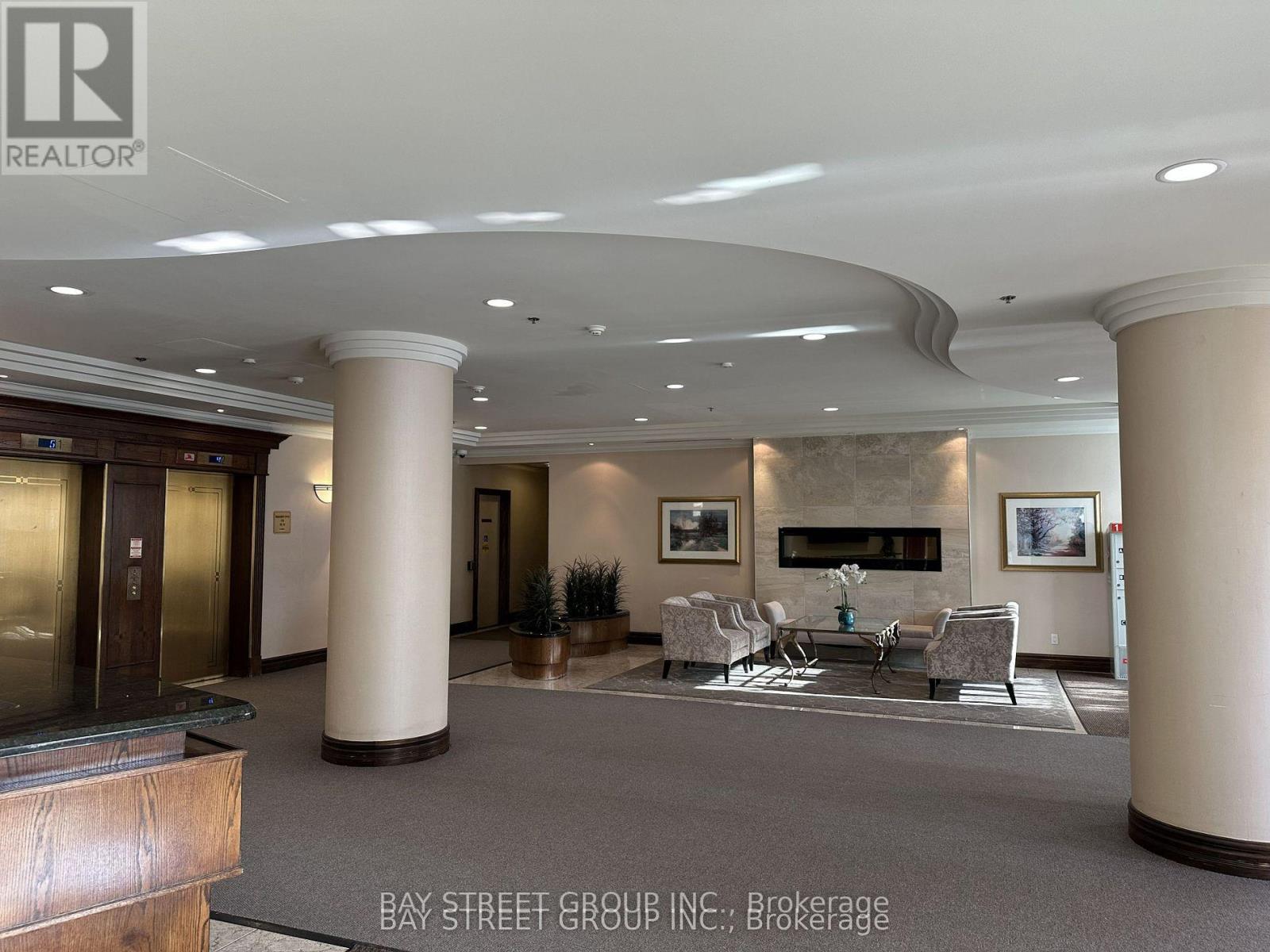 A spacious lobby with a fireplace and seating area.