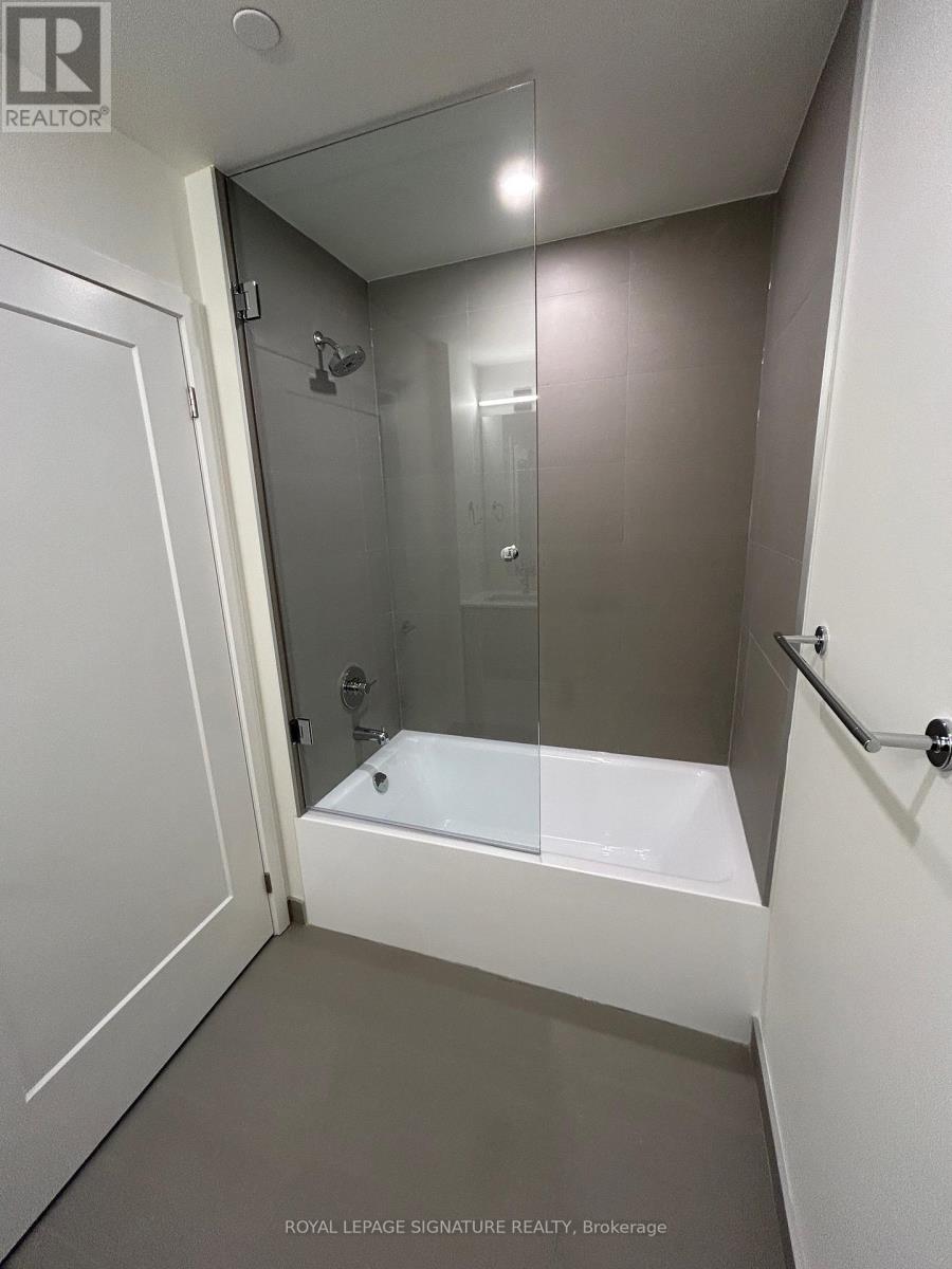A white bathroom with a glass shower door and a white bathtub.