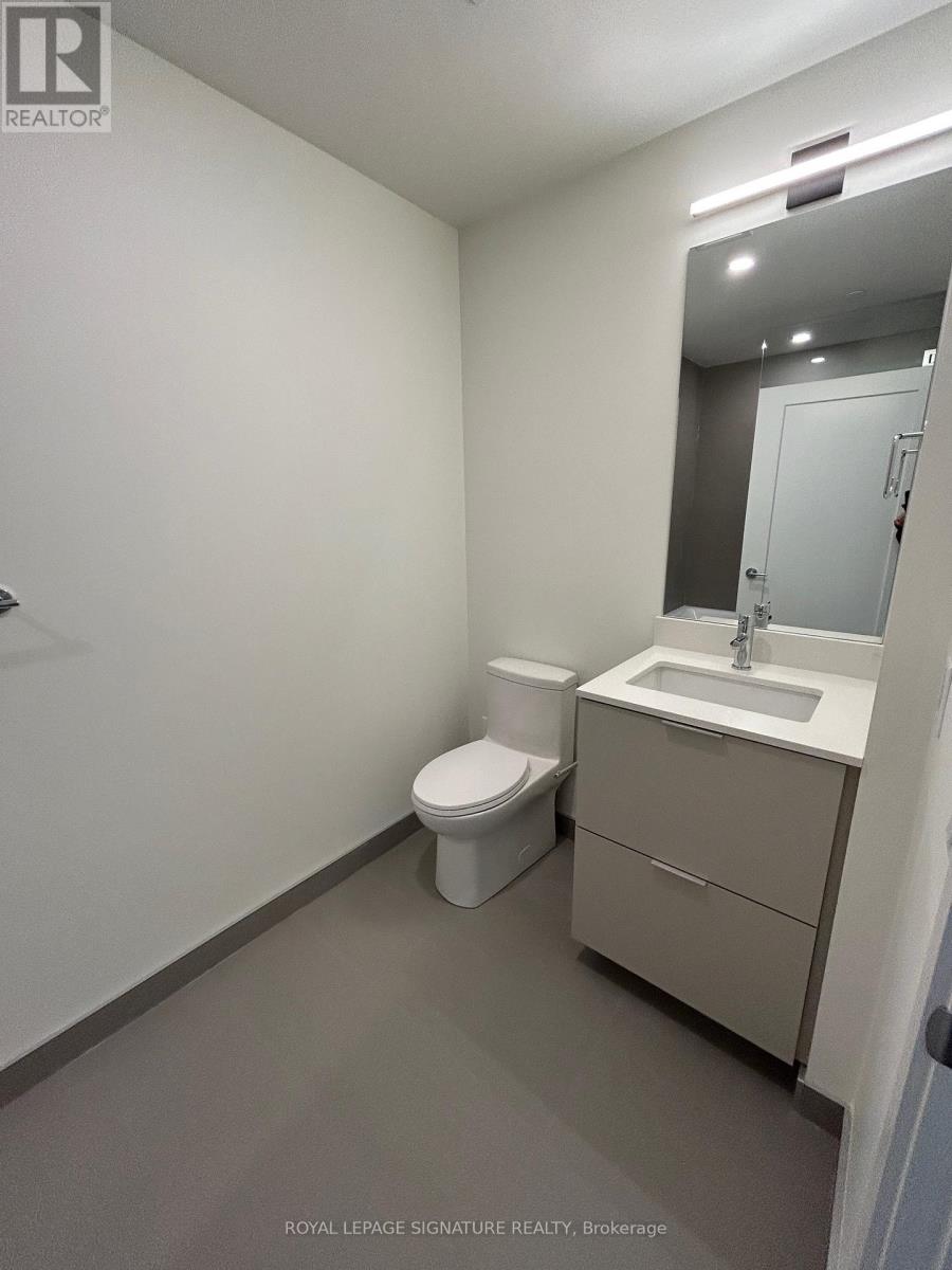 A white bathroom with a toilet, sink and mirror.