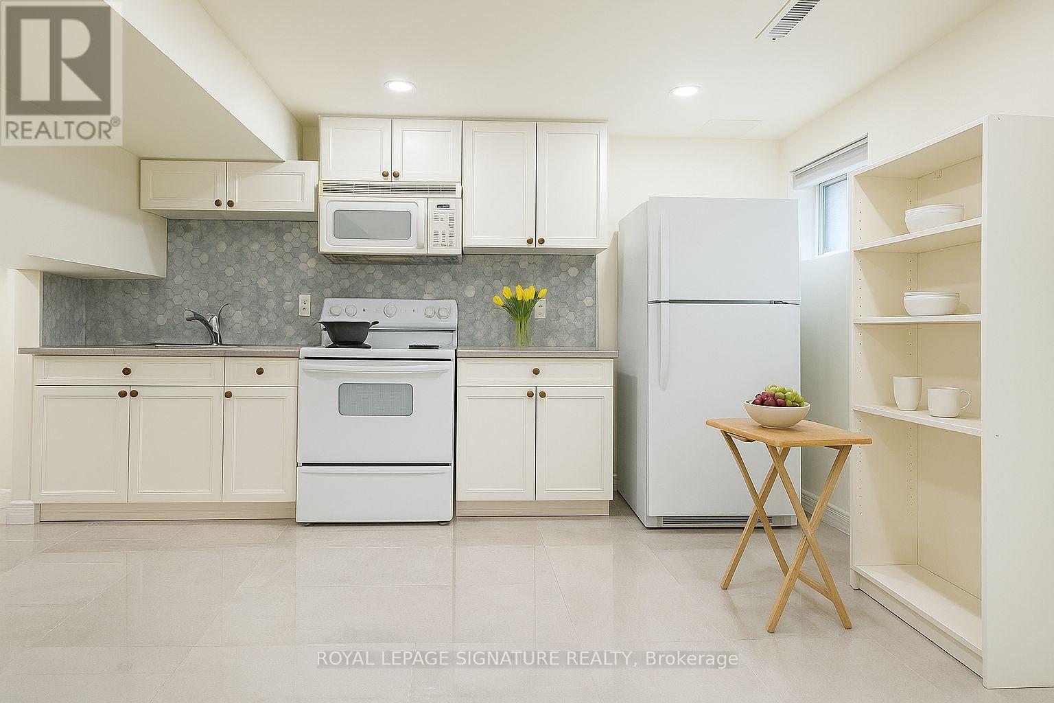 A kitchen with white appliances and cabinets.