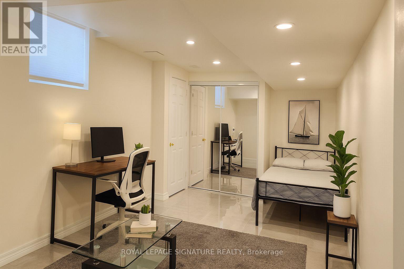A well-lit bedroom with a bed, desk, and chair.