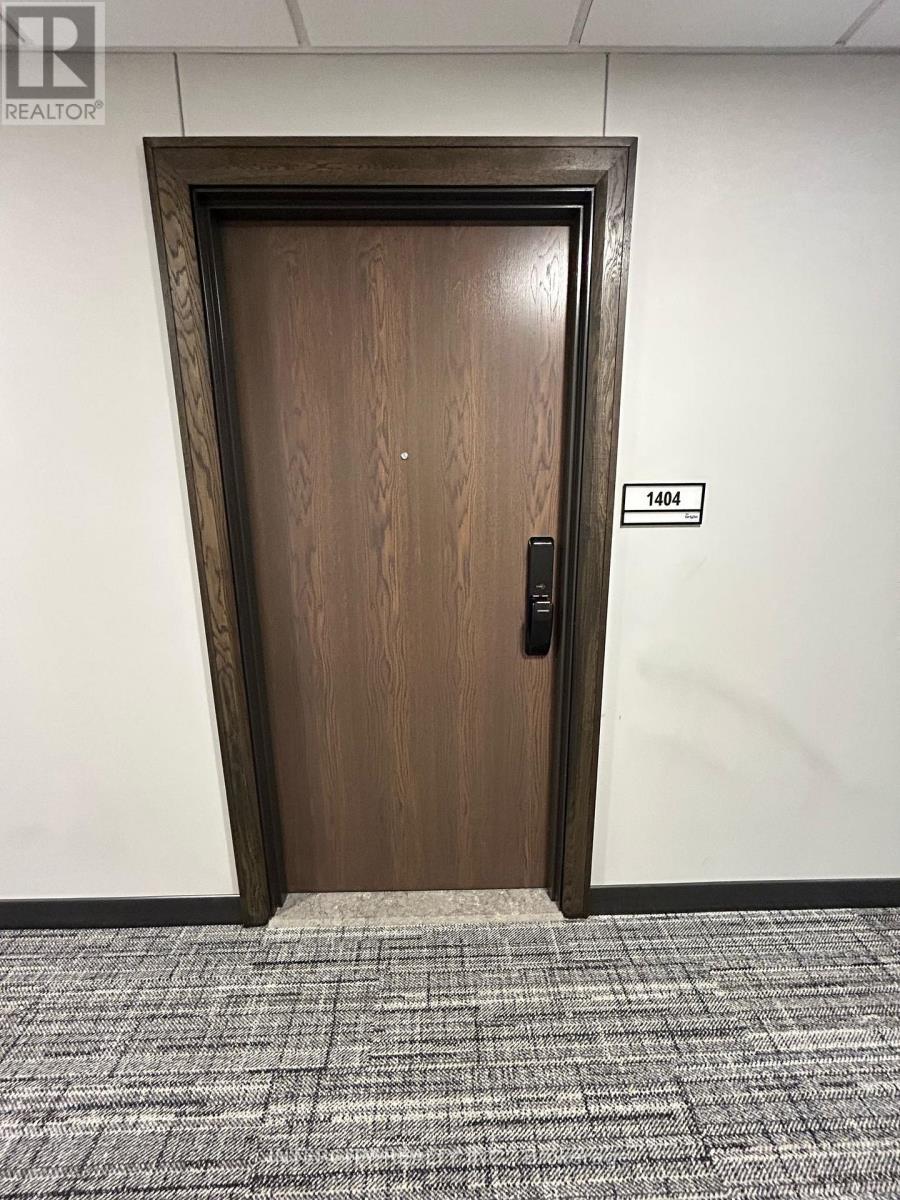 A brown door with a black handle and a sign above it that says 1404.