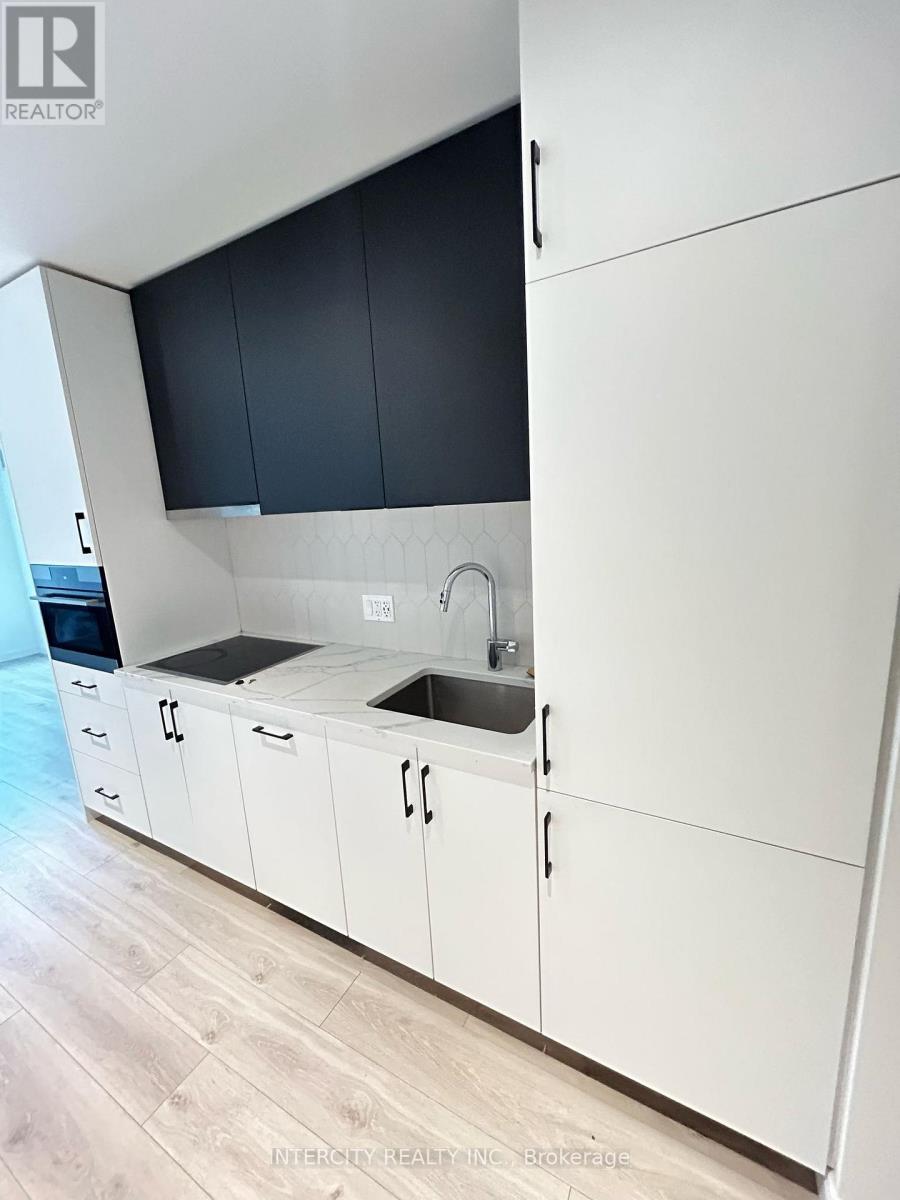 A kitchen with white cabinets and a black countertop.