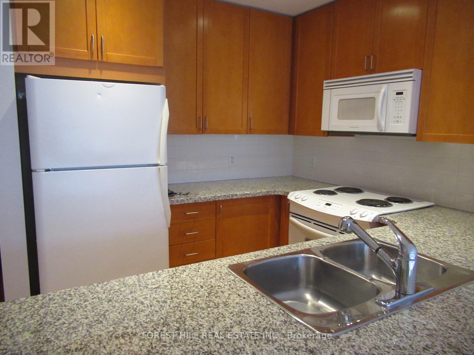 A kitchen with a white fridge, a microwave, and a stove top oven.
