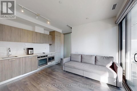 A modern kitchen with a couch in the living room.