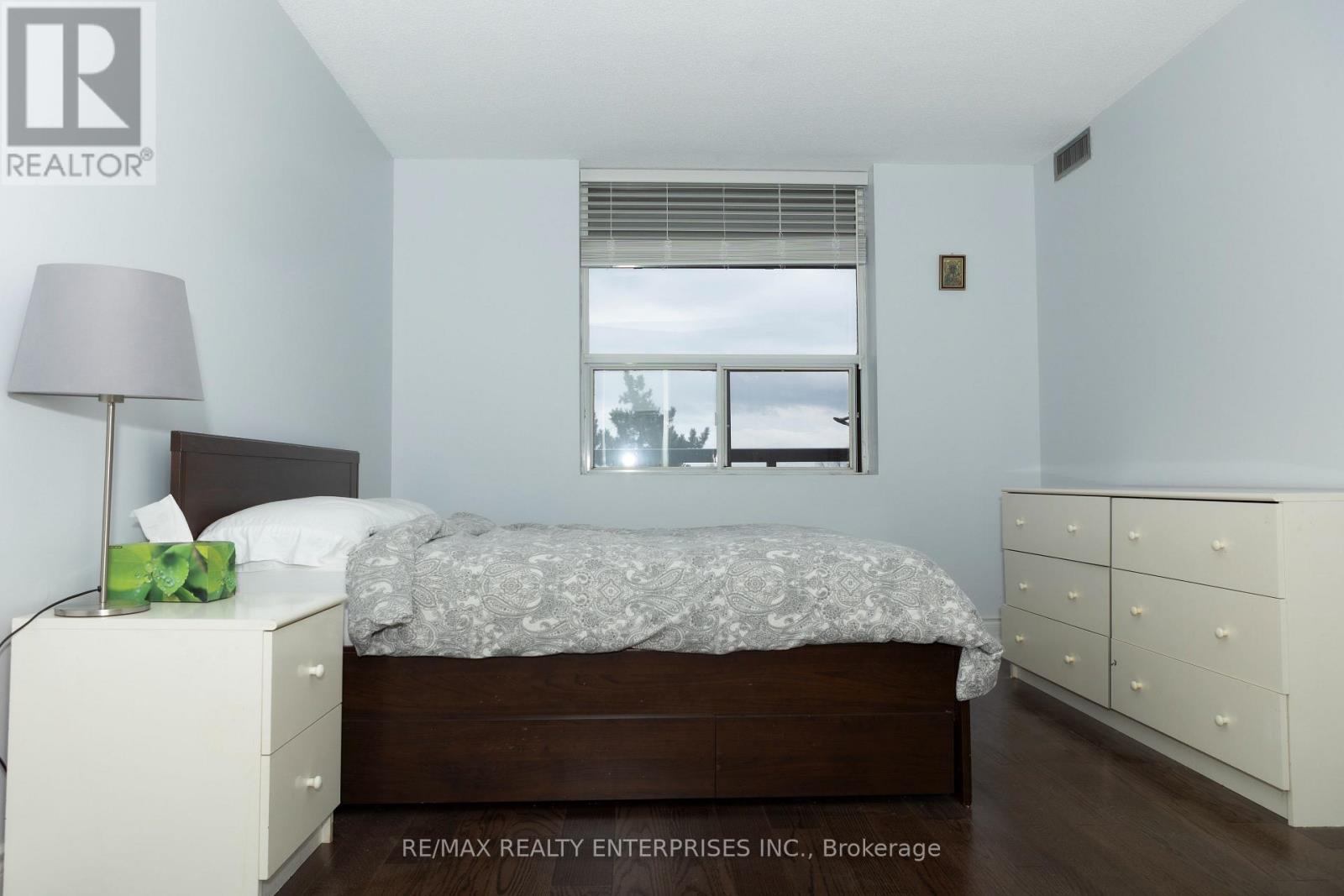 A bedroom with a bed, nightstand, and dresser.