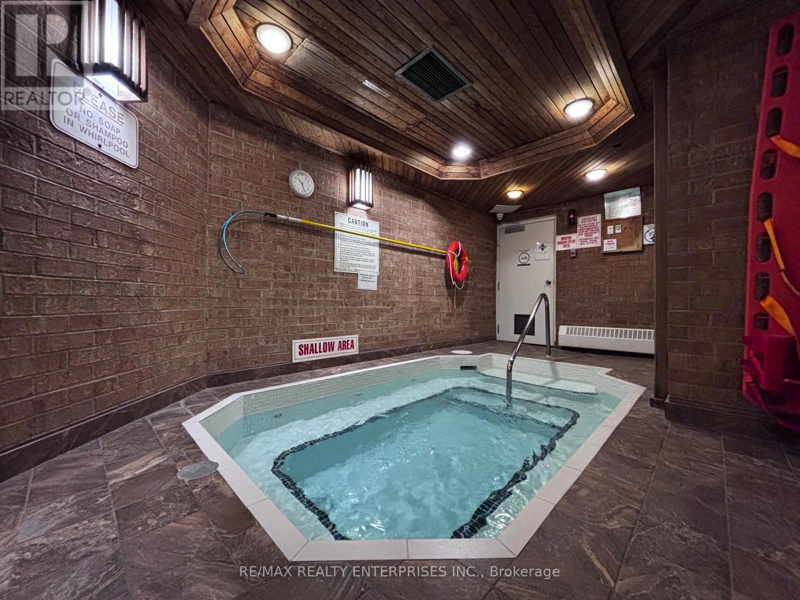 A small indoor swimming pool with a sign that says shallow area.