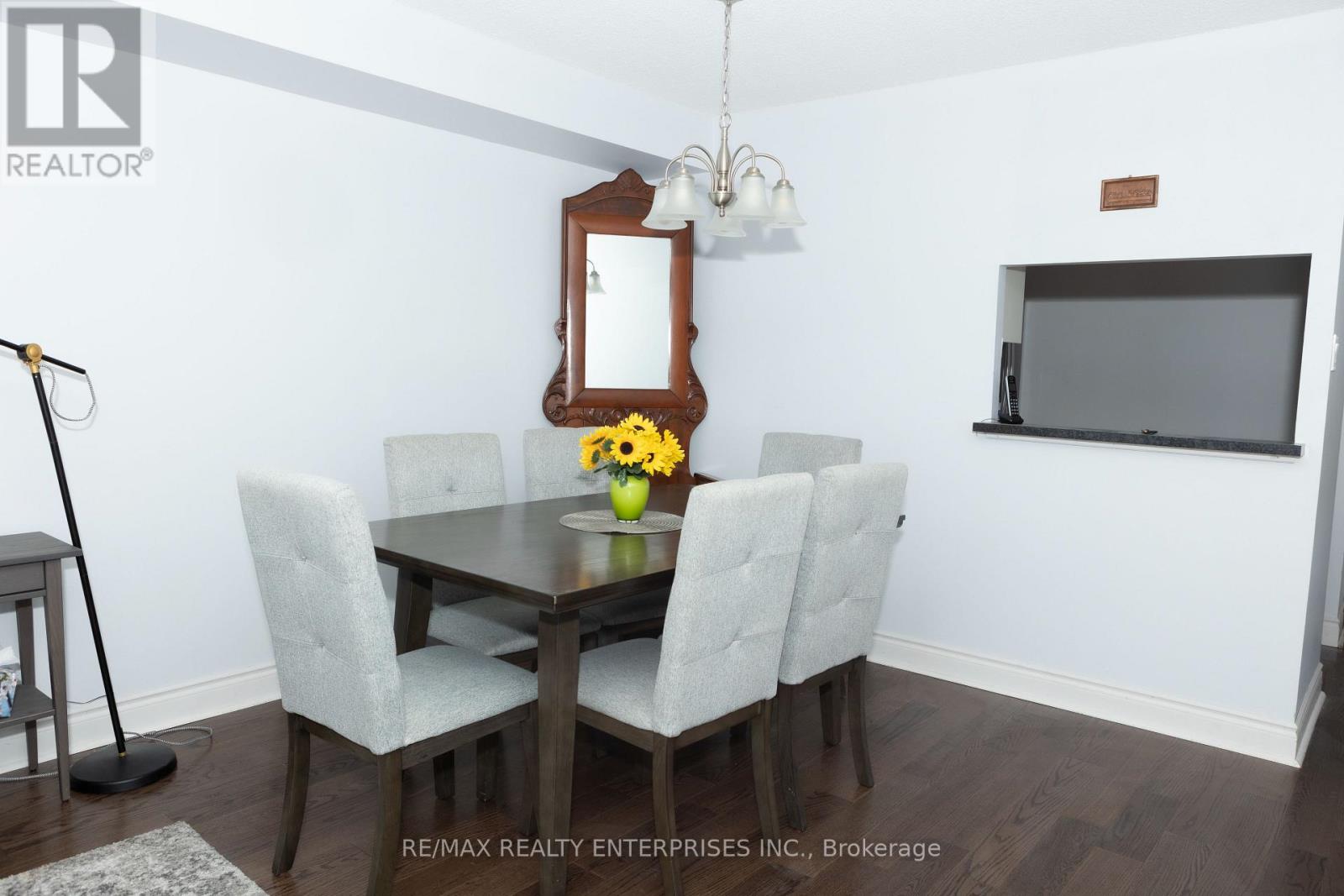 A dining room with a table, chairs, and a mirror.