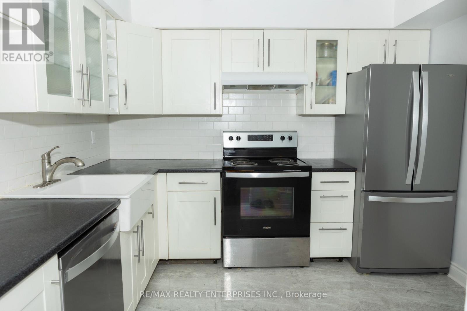 A modern kitchen with white cabinets and stainless steel appliances.