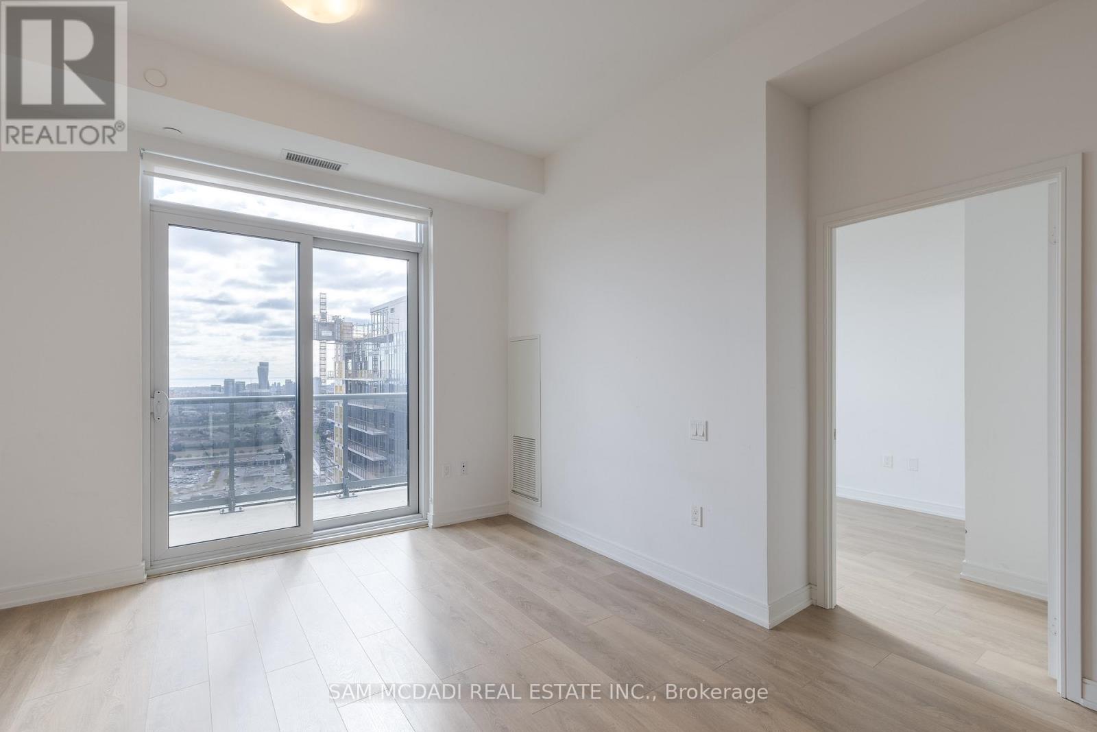 A room with a sliding glass door leading to a balcony.