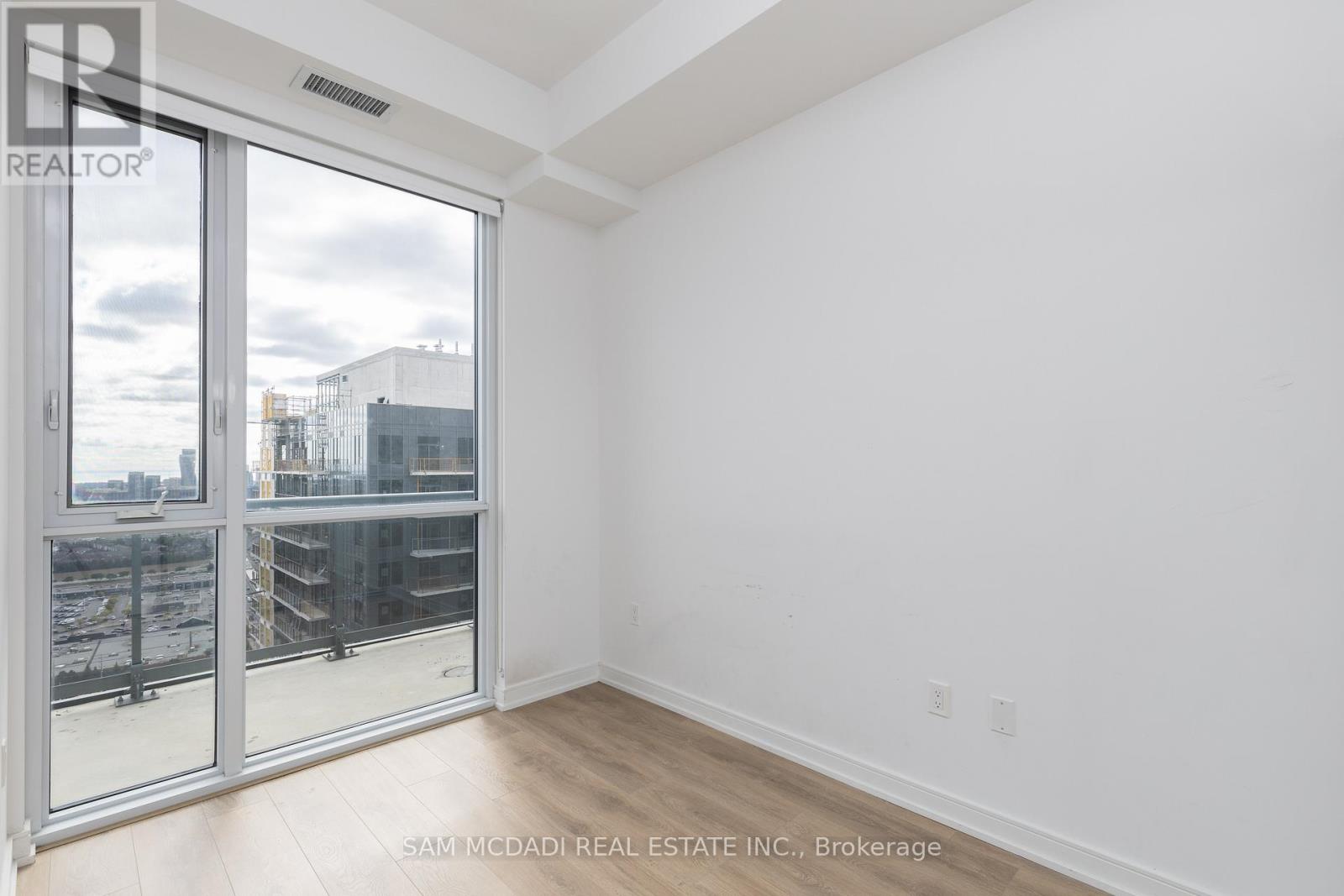 A room with a view of a construction site through a glass door.