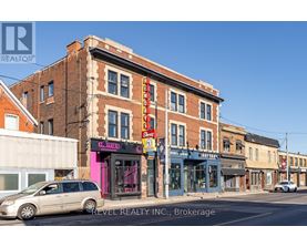 A street view with a building that has a pink sign on it.