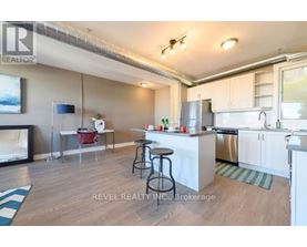 A kitchen with white cabinets and a wooden floor.