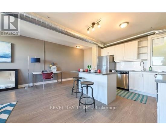 A kitchen with white cabinets and a wooden floor.