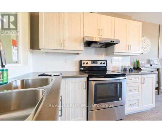 A kitchen with a stove, oven, and sink.