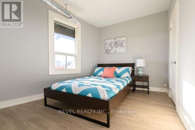 A bedroom with a bed, nightstand, and lamp.