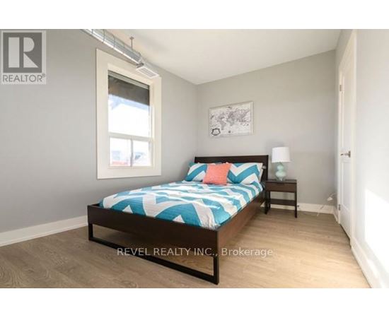 A bedroom with a bed, nightstand, and lamp.