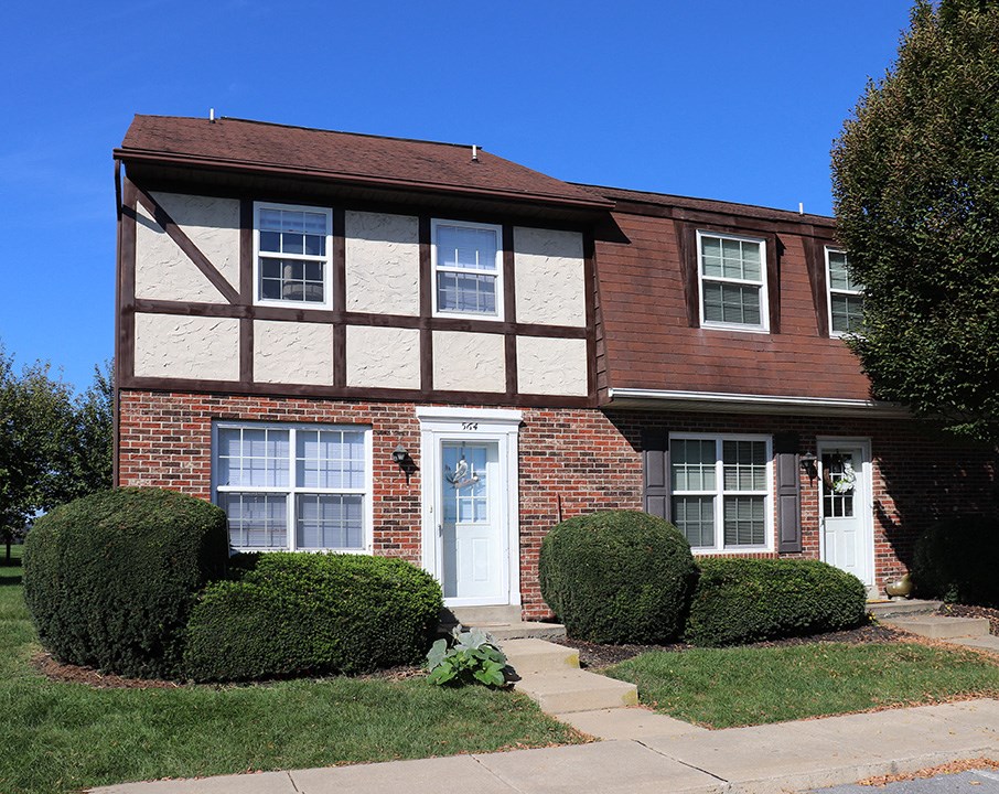a brick house with white windows and a white door