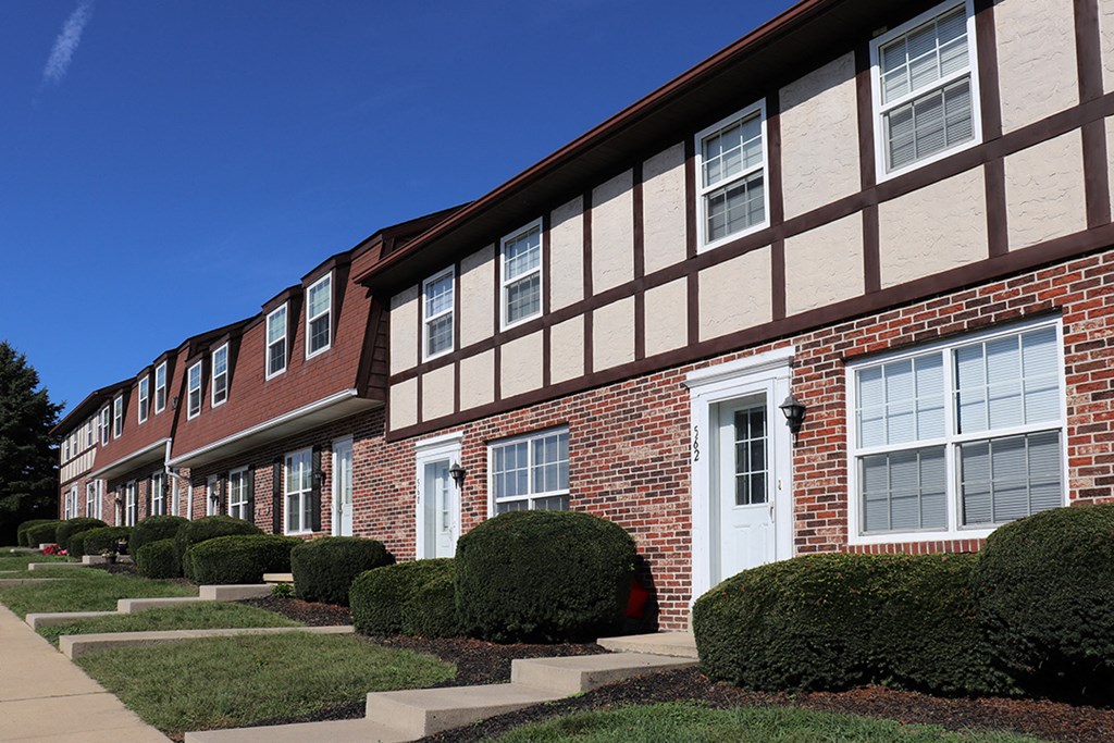 a brick building with shrubs in front of it