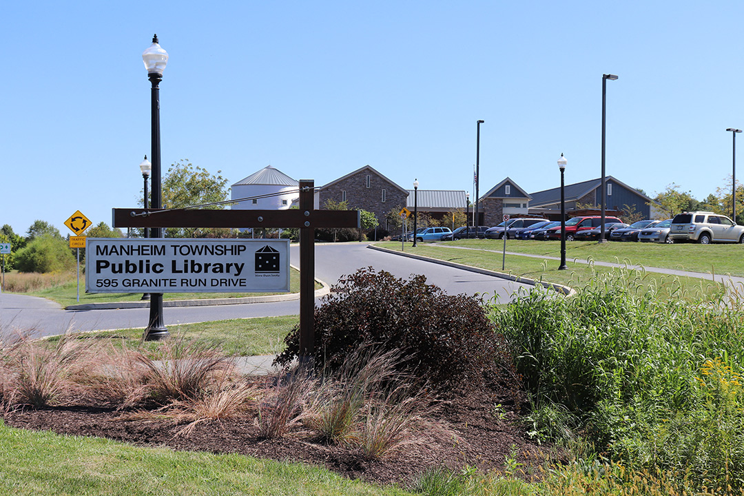 a sign for the township public library in front of a road