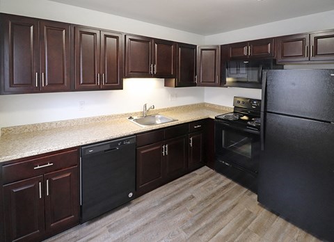 a kitchen with dark wood cabinets and a sink and a refrigerator