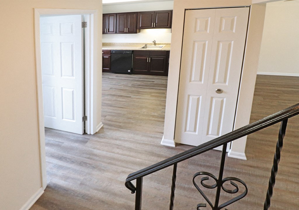 a view of a living room and a kitchen from a staircase