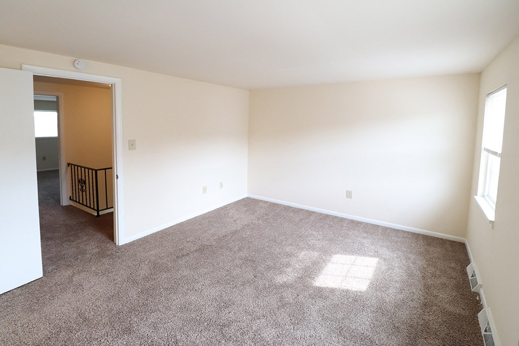 an empty living room with carpet and white walls