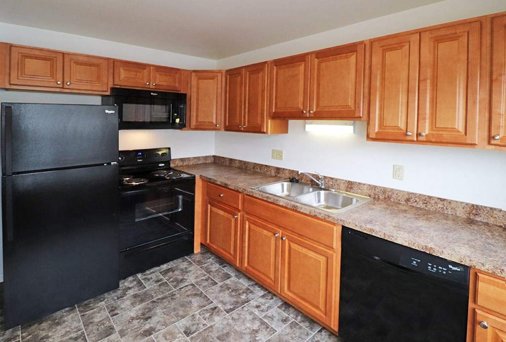 a kitchen with black appliances and wooden cabinets