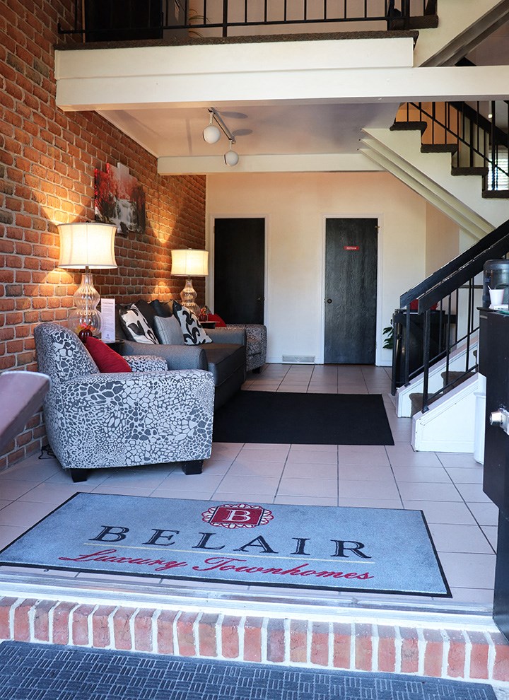 a living room with a rug and a staircase