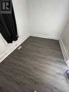 A room with a wooden floor and a black curtain.