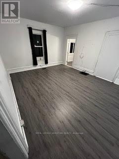 A room with wood flooring and white walls.