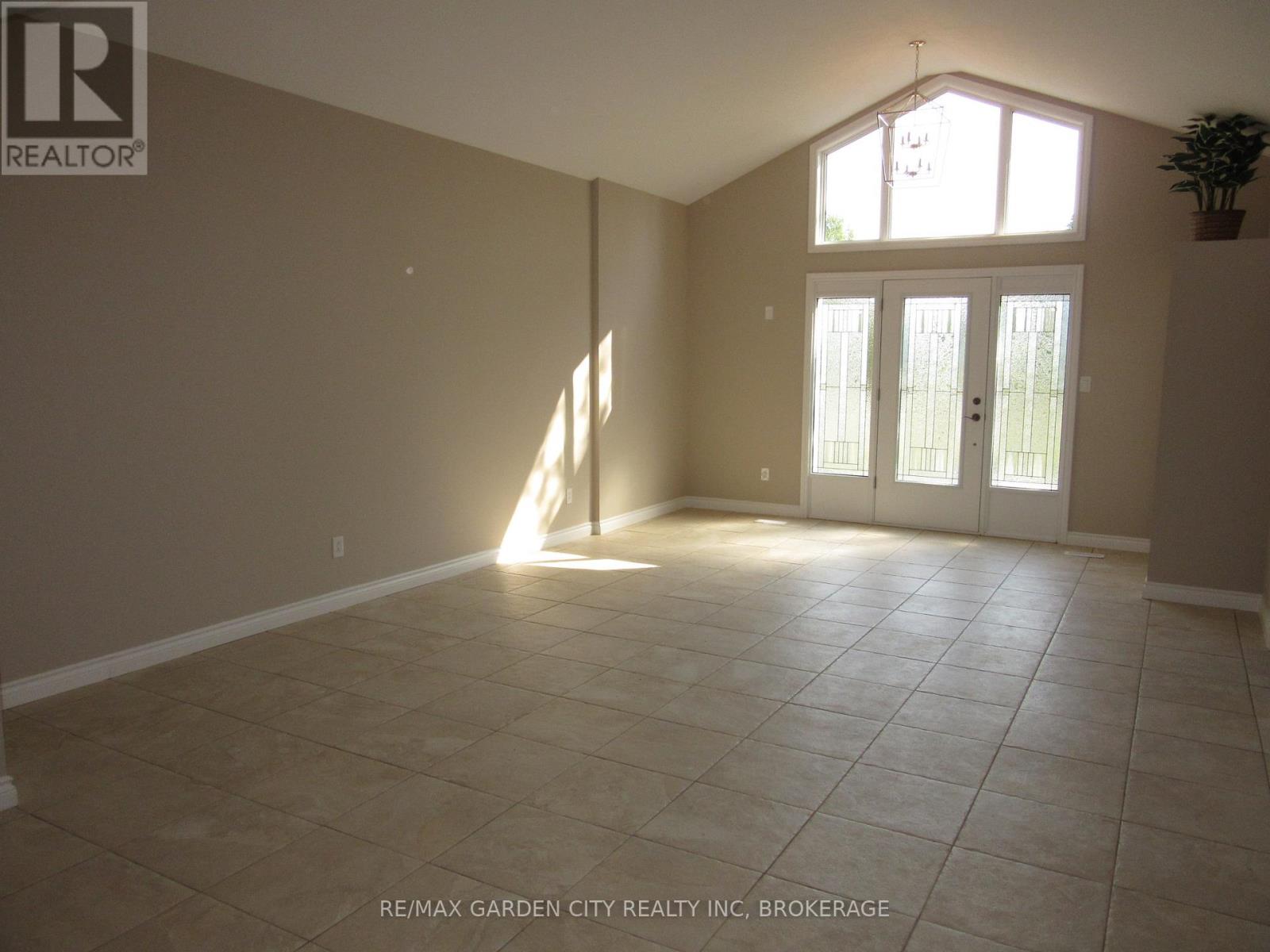 A sunny room with tile flooring and a large window.