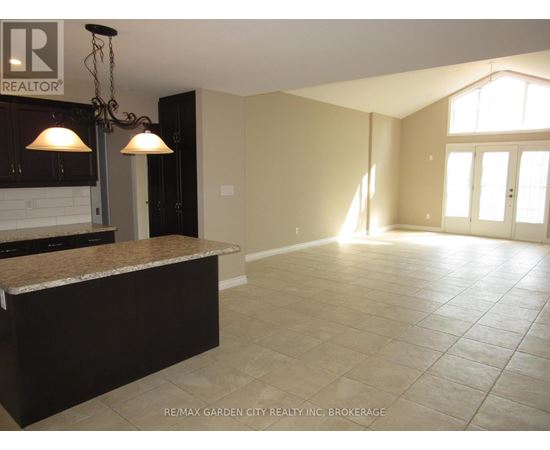 A sunny room with tile flooring and a large window.