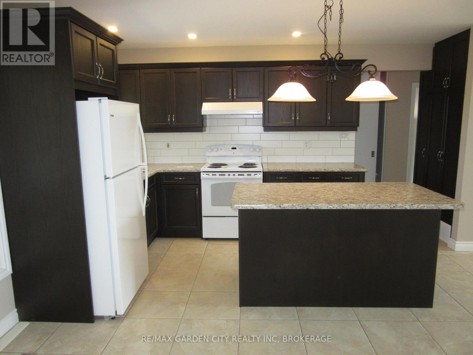 A spacious room with a large window and tiled floor.