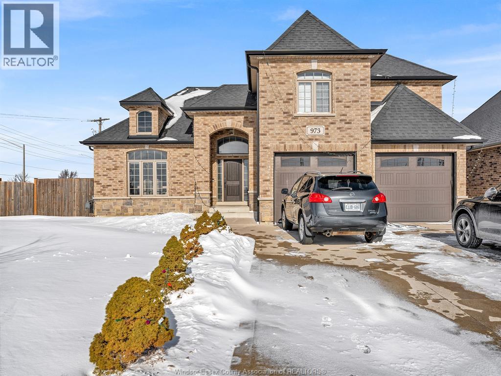 A house with the number 973 on it is shown with a car parked in front.