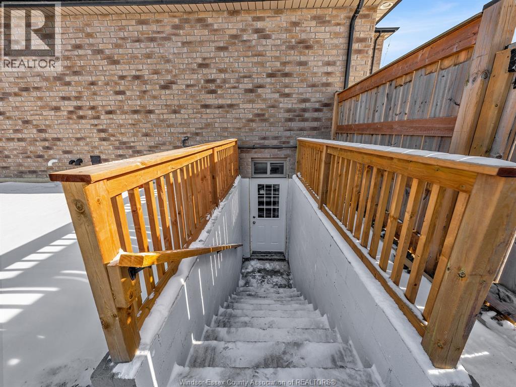 A wooden staircase with a railing leads up to a door.