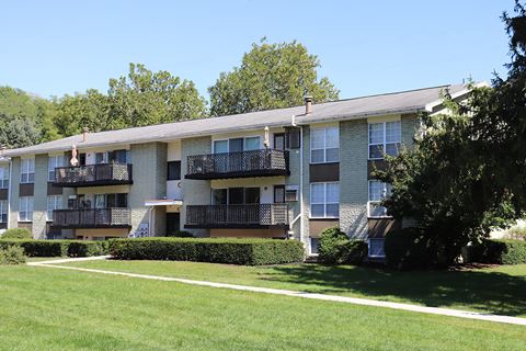 an apartment building with balconies and a grass yard