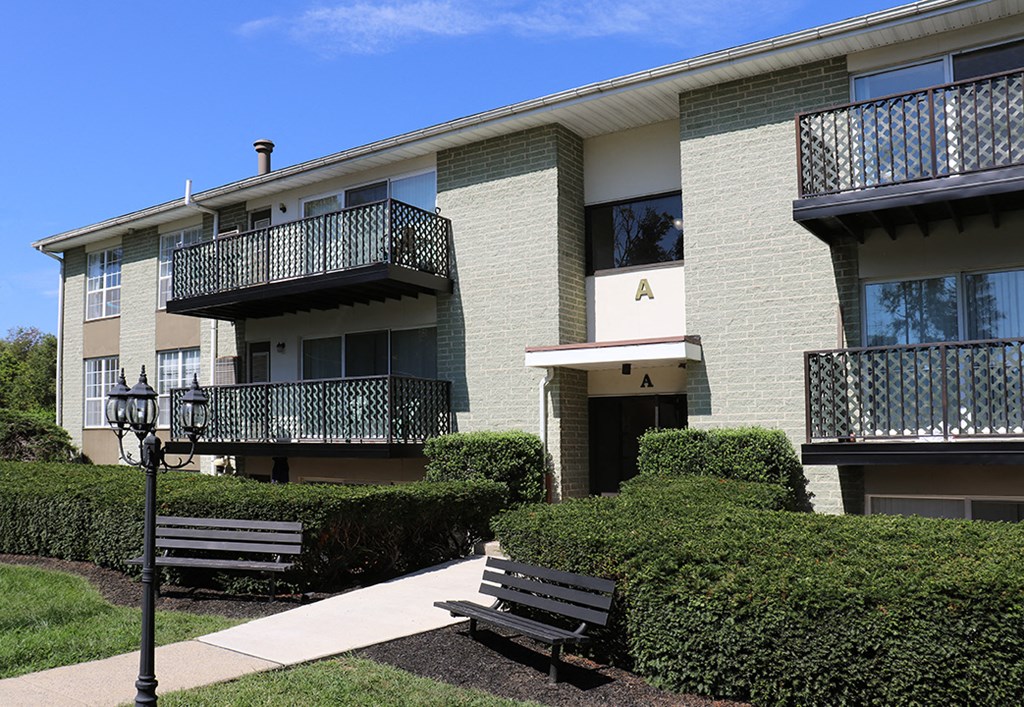 an apartment building with two benches in front of it