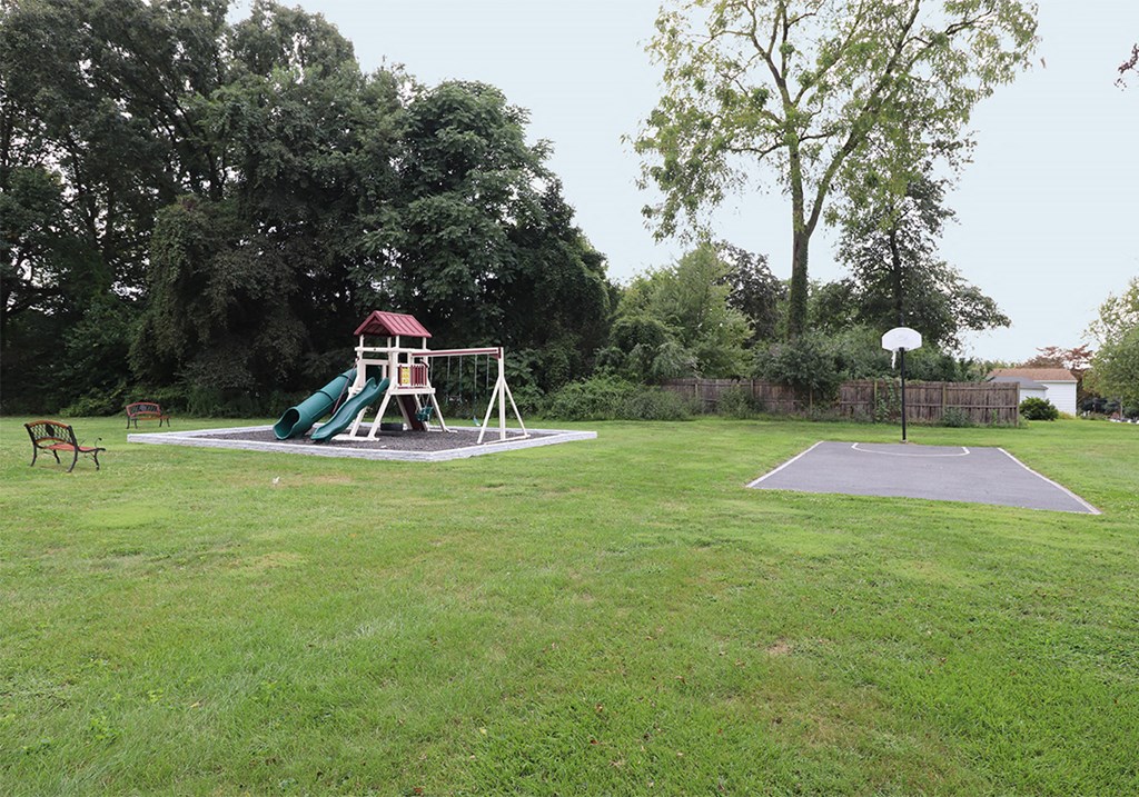 a playground with a swing set and a basketball court