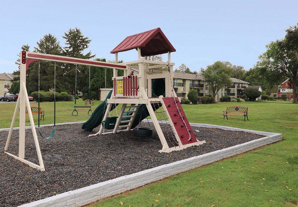 a playground with a swing set in a park