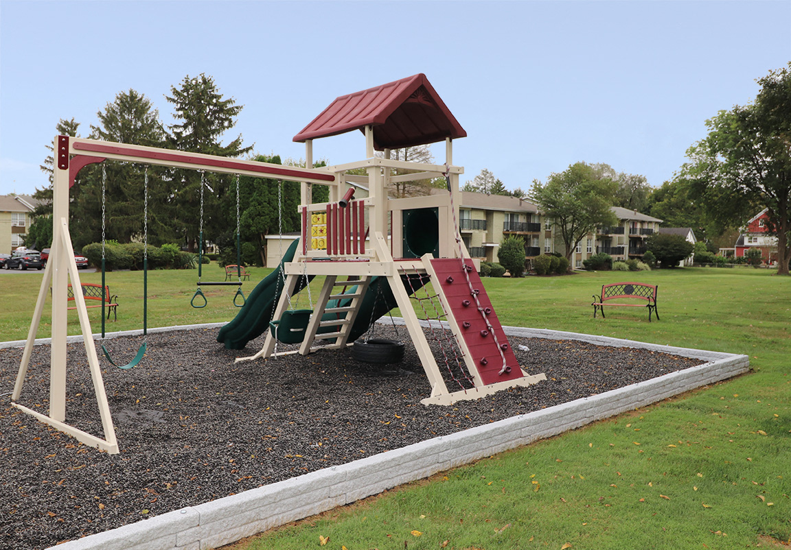 a playground with a swing set in a park