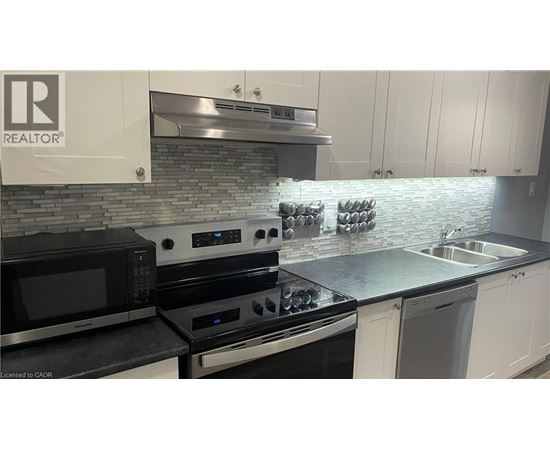 A modern kitchen with a stove top oven and microwave.