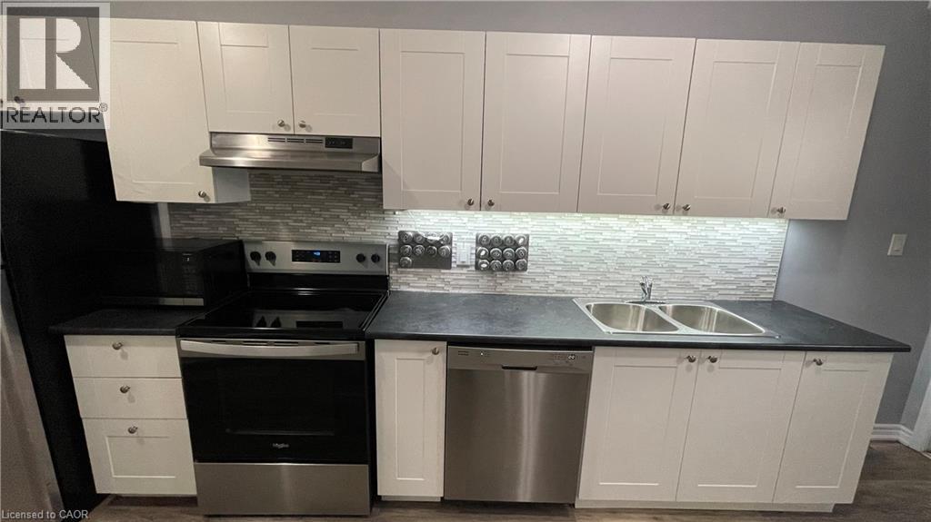 A kitchen with white cabinets and a black countertop.